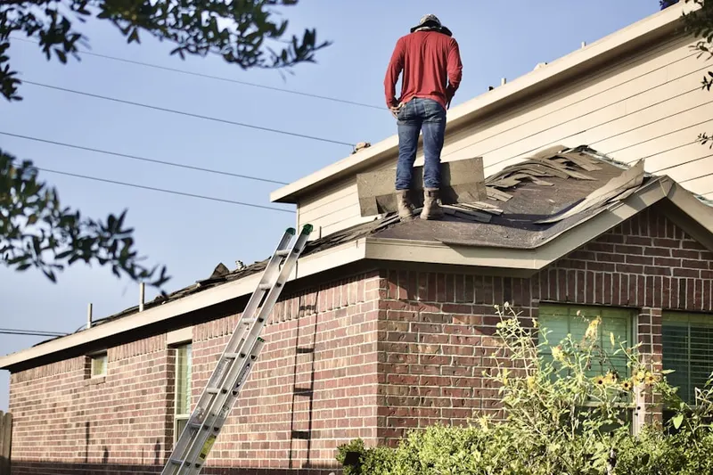 Professional roofer working on a residential roof in Woodbury